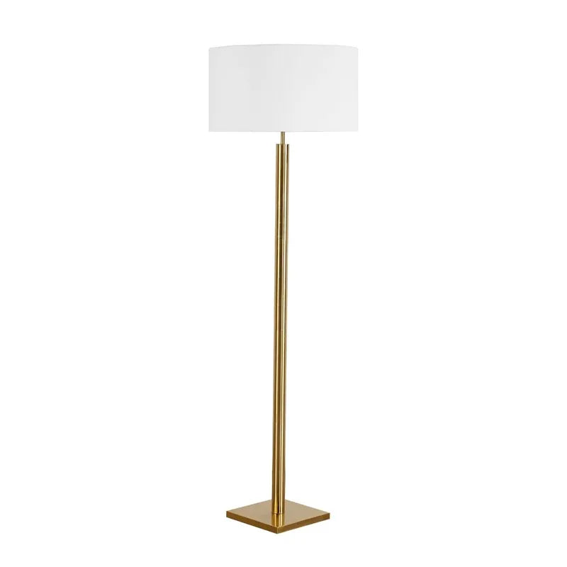 Floor lamp with a white shade and gold base on a white background